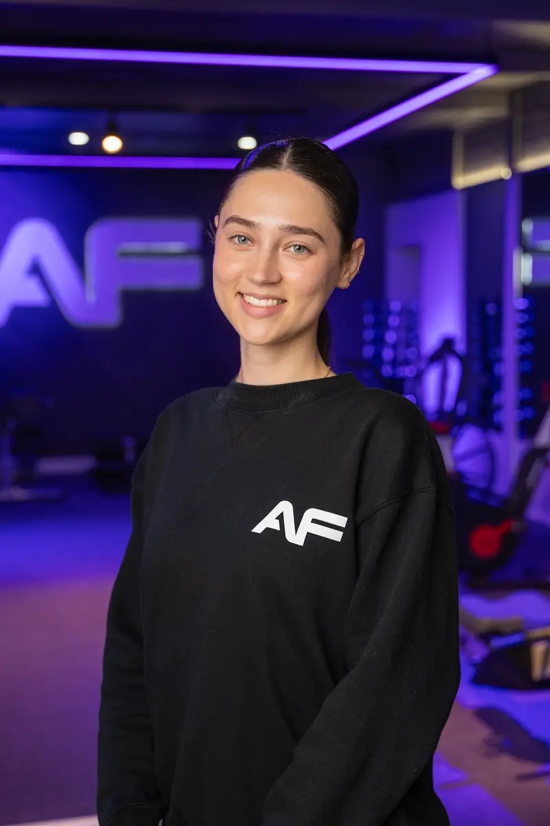 Bria, the club manager, smiling in the purple room