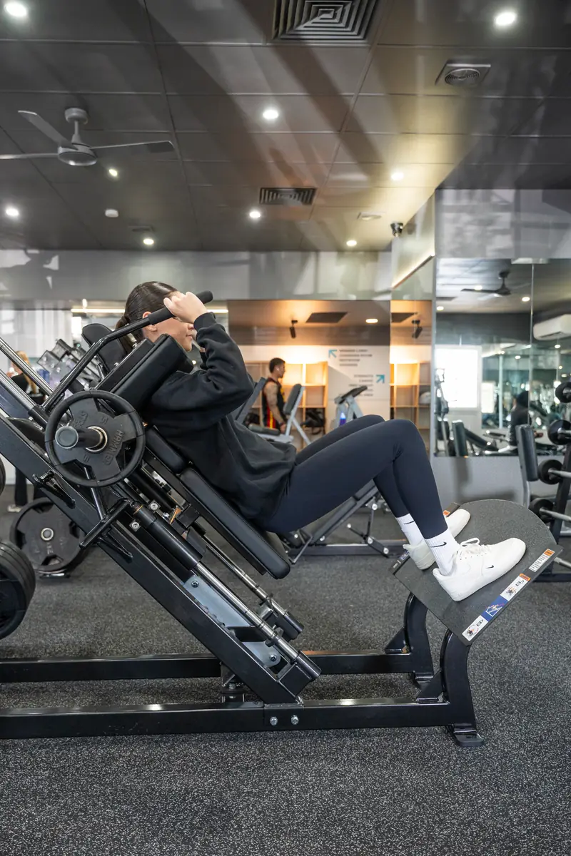 A staff member on the hack squat